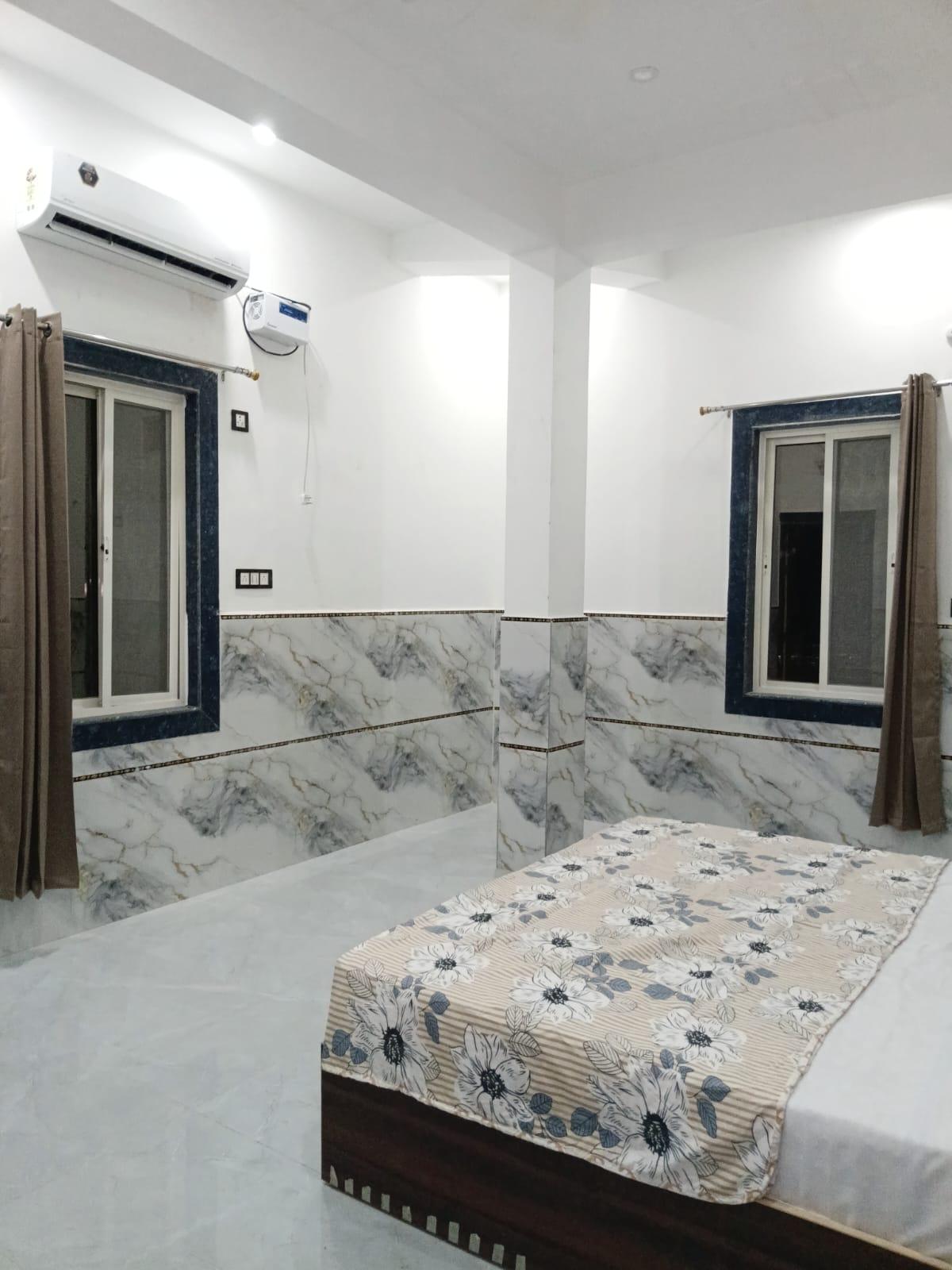 Air-conditioned room with a wall-mounted AC, two windows and curtains